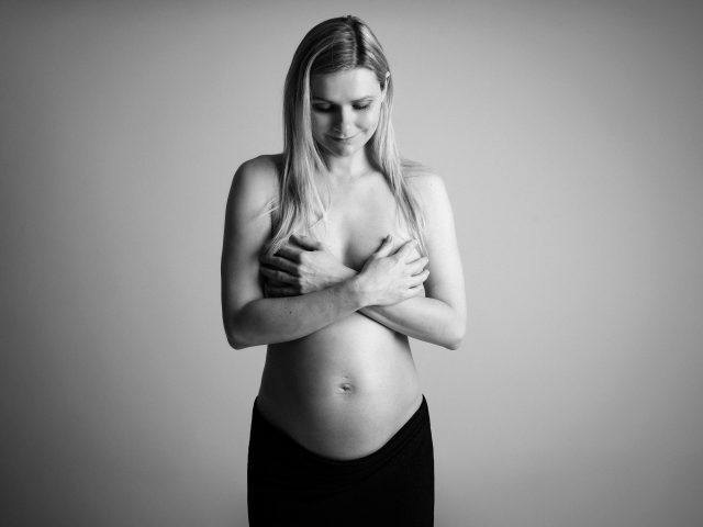 černobílá portrétní fotografie těhotné ženy na těhotenském focení v ateliéru