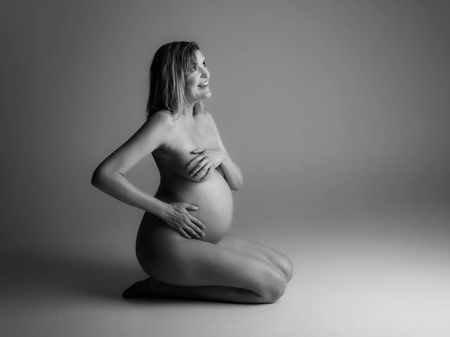 černobílá těhotenská fotka sedící žena v ateliéru V Praze