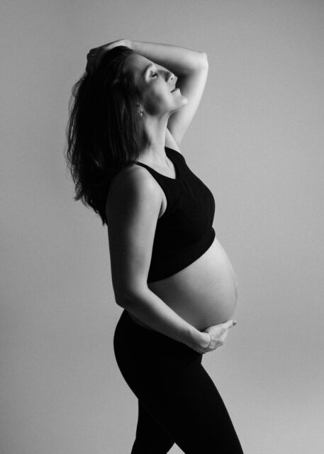 umělecká minimalistická fotografie těhotně ženy ve fotoateliéru