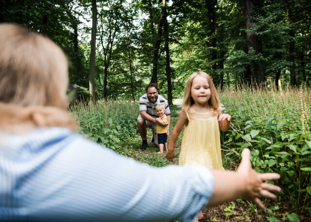 rodinné foto děvče si hraje s rodiči v lese