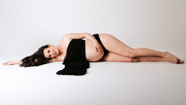 ležící těhotná žena s černým šátkem na podlaze v ateliéru v Praze