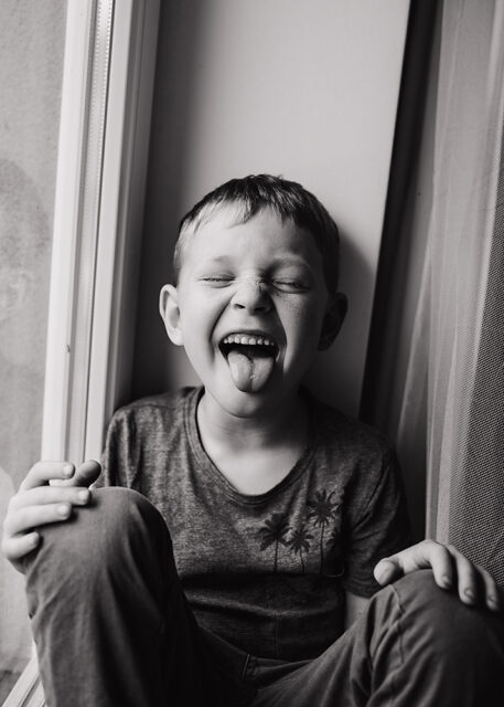 přirozená portrétní fotka chlapce s vyplazeným jazykem
