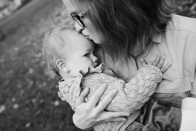 černobílá fotografie miminko se tulí k mamince