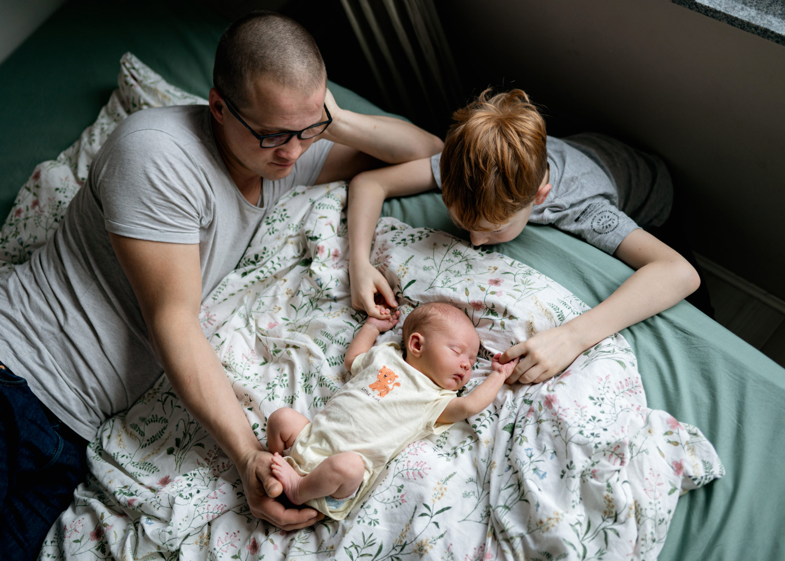 rodinné foto z lifestylového focení miminko na posteli se sourozencem a tatínkem