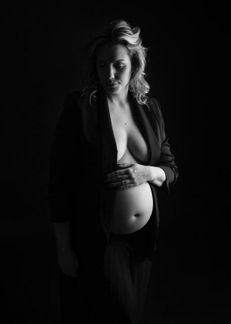černobílý stínový portrét těhotné ženy na černém pozadí na profesionálním těhotenském focení v ateliéru v Praze