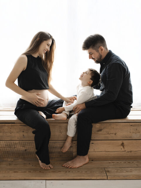 rodina sedící v okně na těhotenském focení v ateliéru v Praze