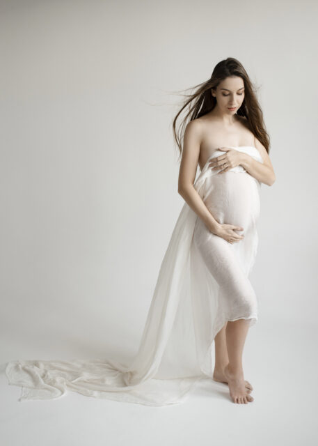 minimalistická fotografie těhotné ženy v bílém šátku na těhotenském focení v ateliéru v Praze