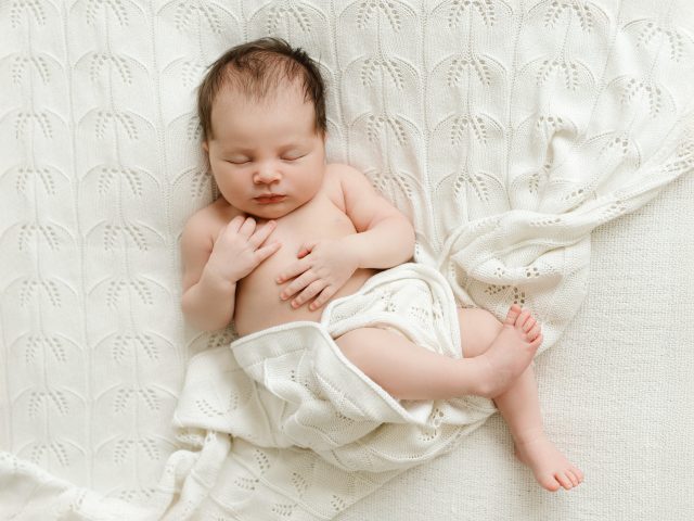 spící miminko v bílé dečce na newborn focení v Praze